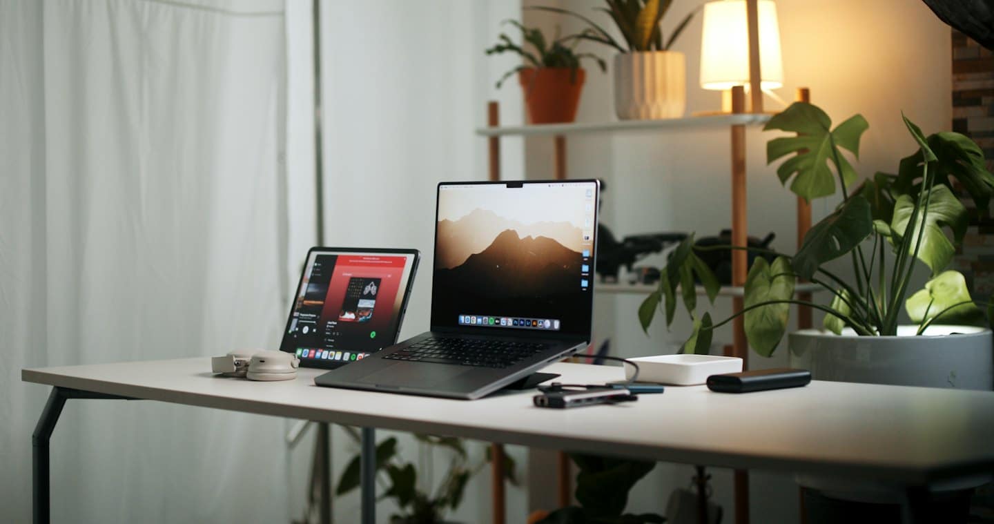 Organized home office with MacBook Pro and iPad on desk.