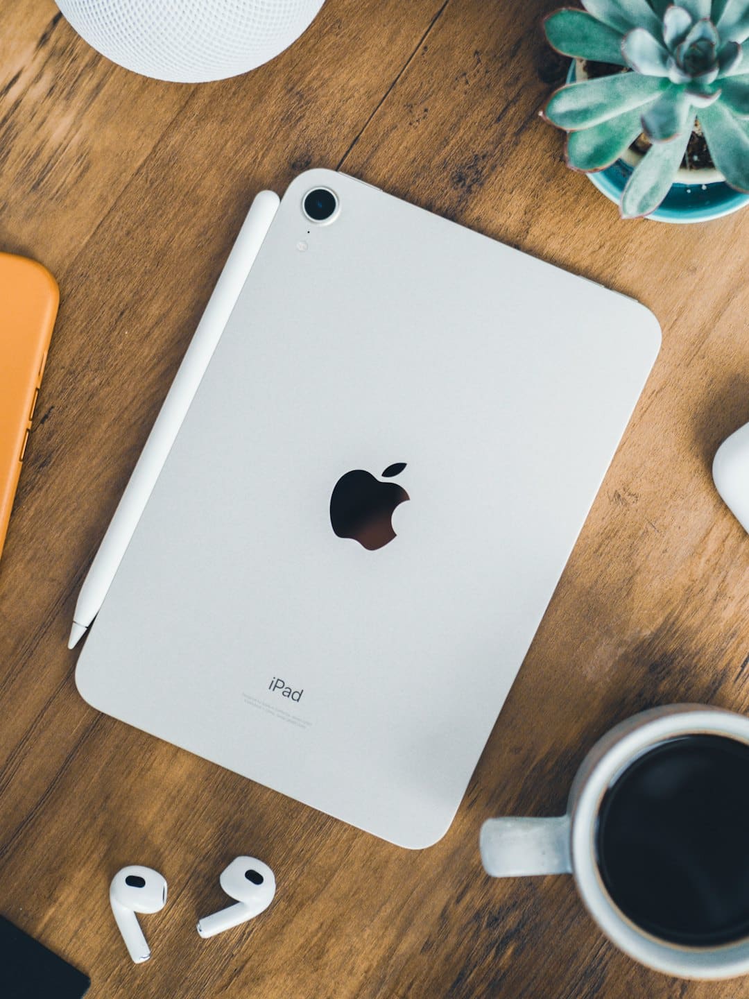 Electronic devices and office supplies arranged on a wooden desk.